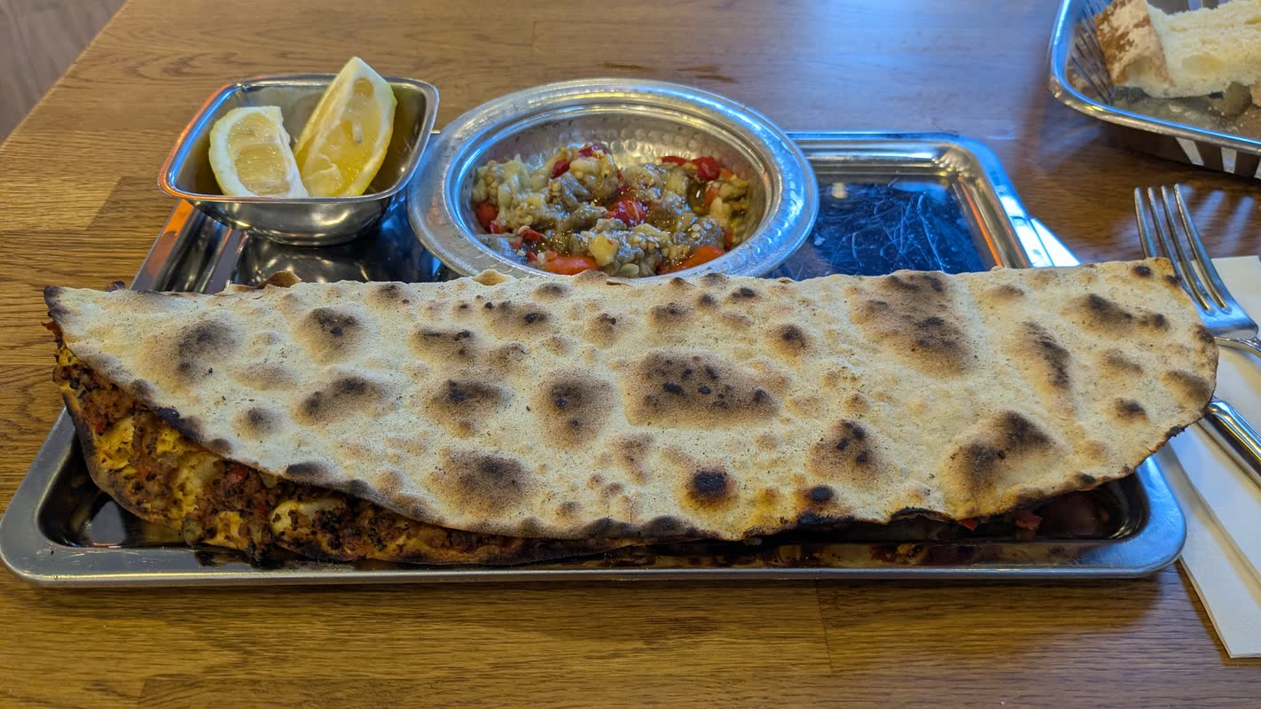 Uzun tepside lahmacun, közlenmiş patlıcan söğürmesi ve limon