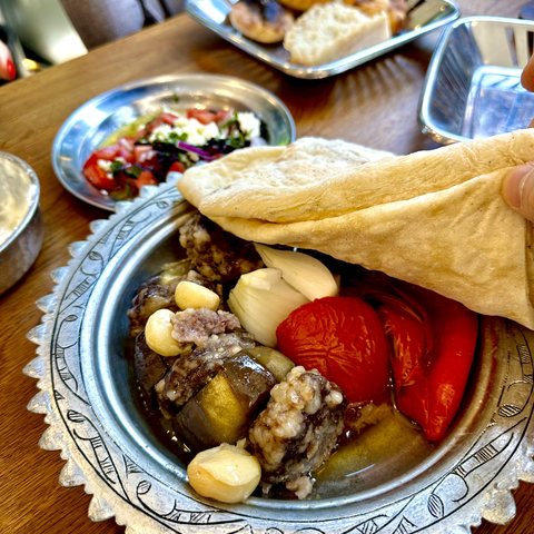 Çini desenli tabakta fırında patlıcan kebabı, közlenmiş biber ve bütün sarımsakla